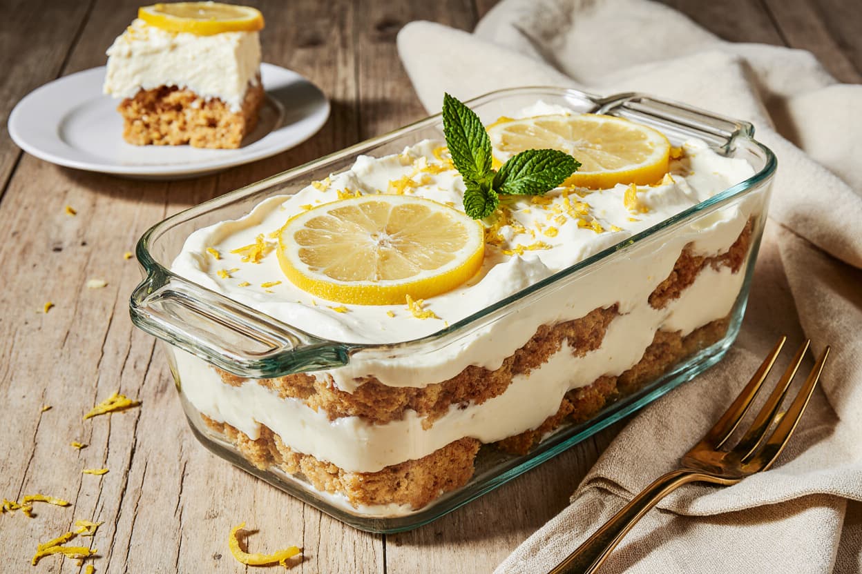 Close-up of Limoncello Tiramisu layered with mascarpone, lemon zest, and ladyfingers in a rectangular dish.
